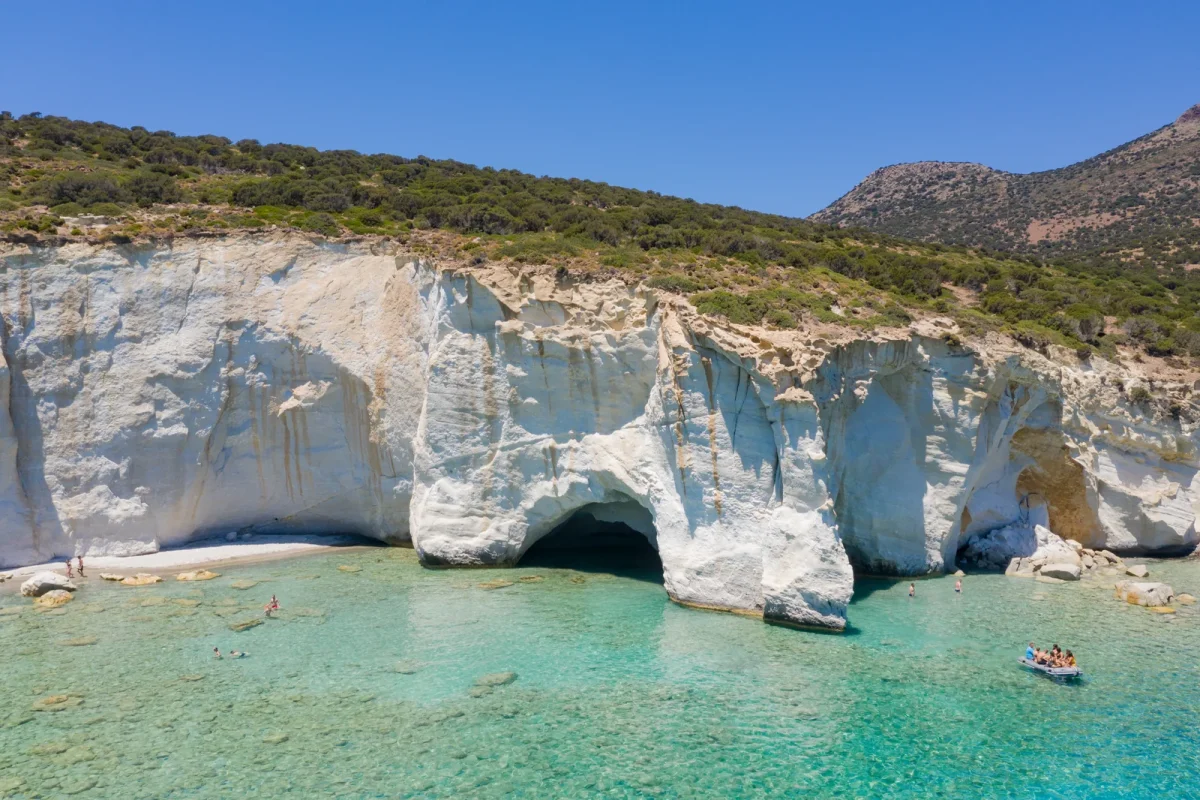 Snorkelers and a small boat at the Kleftiko sea caves, Milos