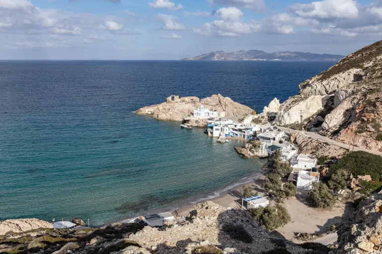 Firopotamos in Milos, a small bay with turquoise water, fishermen's boat houses and a white chapel on the rocks