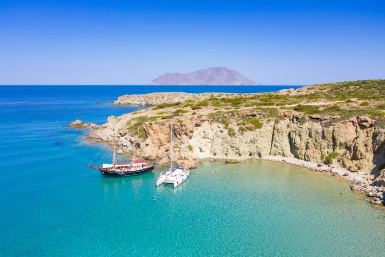 Tour boats anchored below the white cliffs of Kleftiko, Milos, seen from above