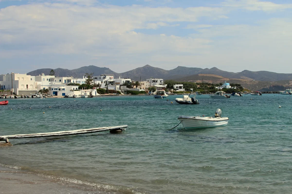 Pollonia in Milos, white houses along the waterfront and small boats moored in the calm bay