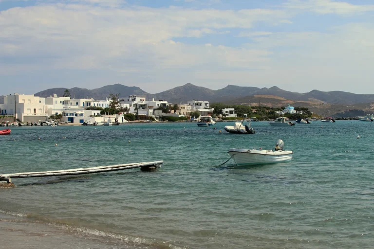 Pollonia in Milos, white houses along the waterfront and small boats moored in the calm bay