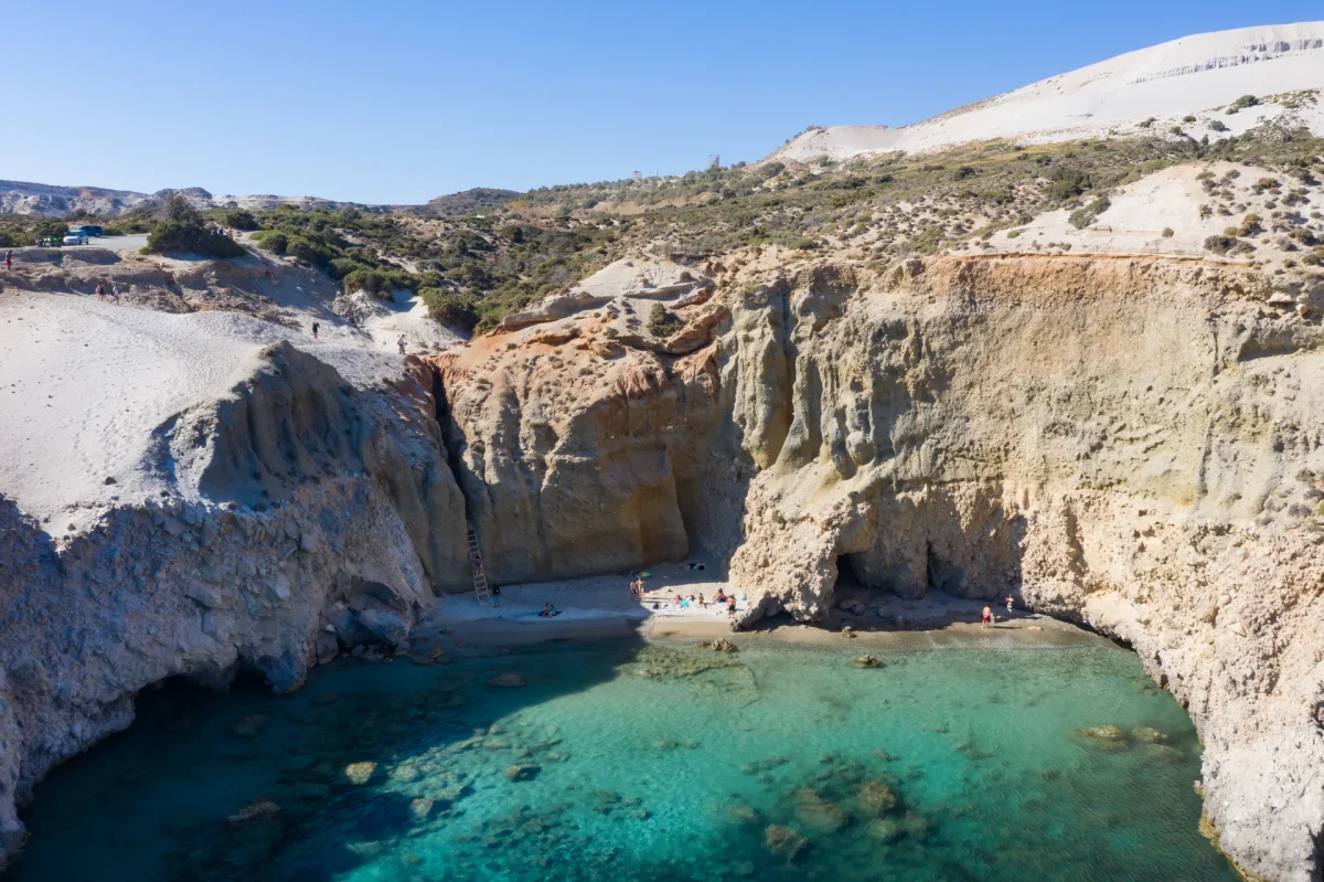 Tsigrado beach in Milos from above, a tiny cove of turquoise water between white cliffs