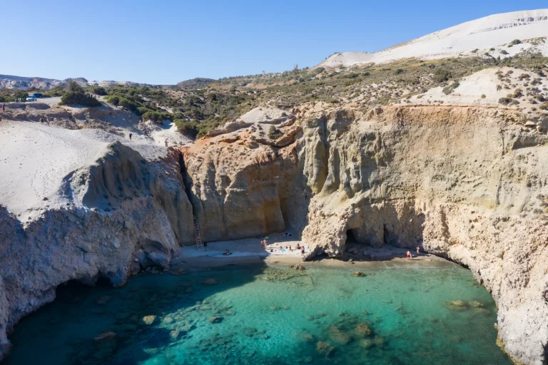 Tsigrado beach in Milos from above, a tiny cove of turquoise water between white cliffs